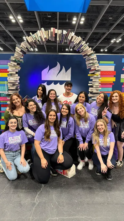Baddies reunidas com camisetas lilás do clube em evento literário