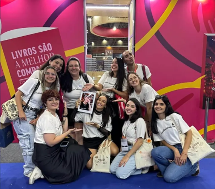 Leitoras posando em um estande colorido de livraria